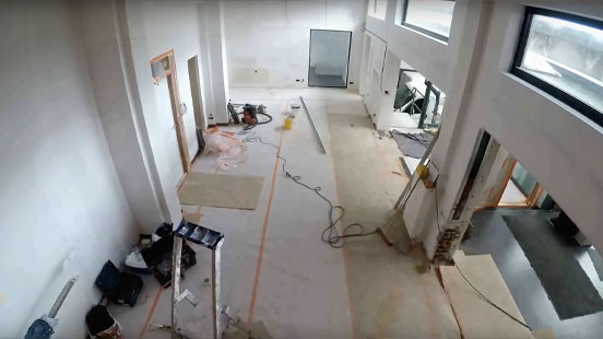 Interieurbeeld van de showroom van D&O Partners in aanbouw, met bouwmaterialen en gereedschap zichtbaar op de vloer, wat de actieve renovatie en het vernieuwingsproces weergeeft.
